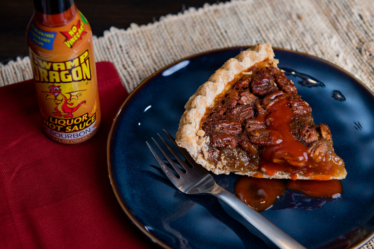 Slice of pecan pie topped with Bourbon Dragon Hot Sauce 