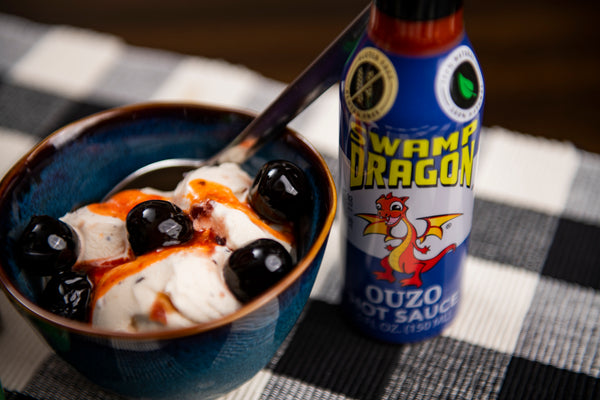 Ouzo Hot Sauce bottle with ice cream and candied cherris, topped with Swamp Dragon Ouzo Hot Sauce