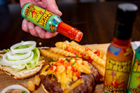 Swamp Dragon Rum Hot Sauce pouring out onto a cheeseburger and french fries
