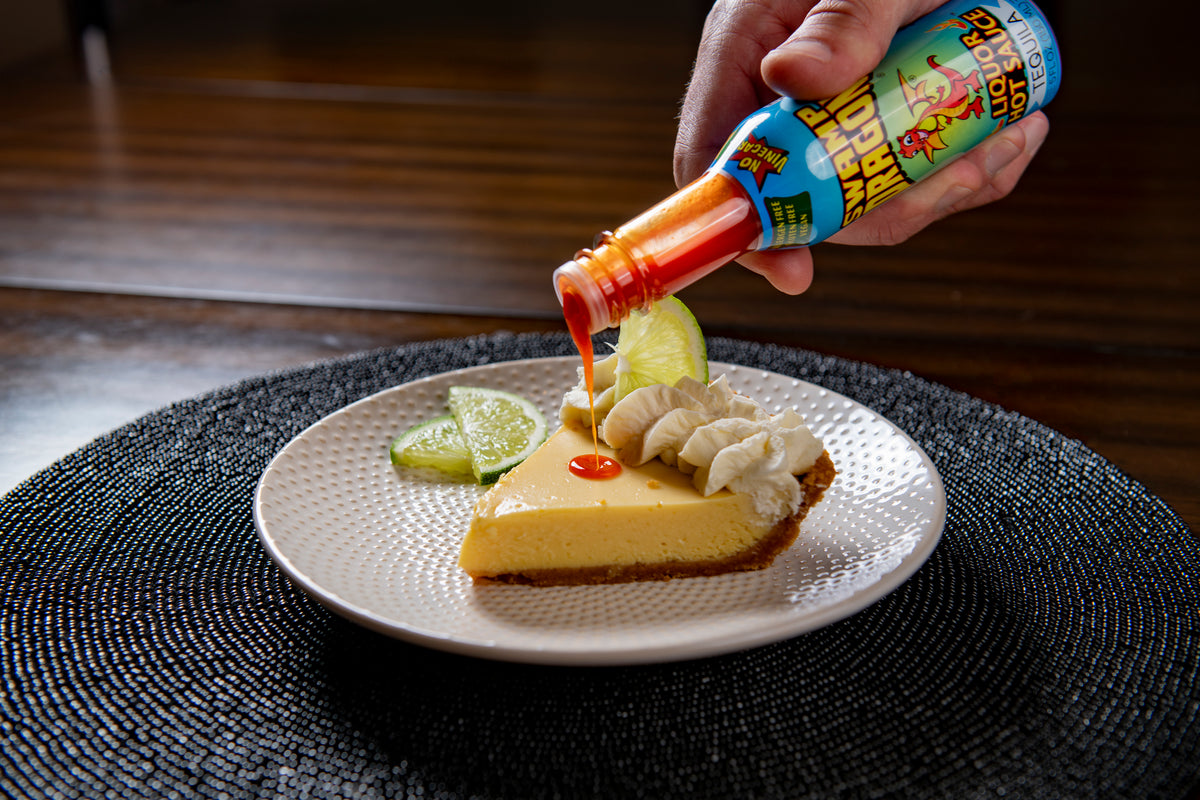 Swamp Dragon Tequila Hot Sauce pouring out onto a slice of key lime pie