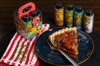 The Dragon Clutch gift sampler box next to a slice of pecan pie, topped with Swamp Dragon Hot Sauce